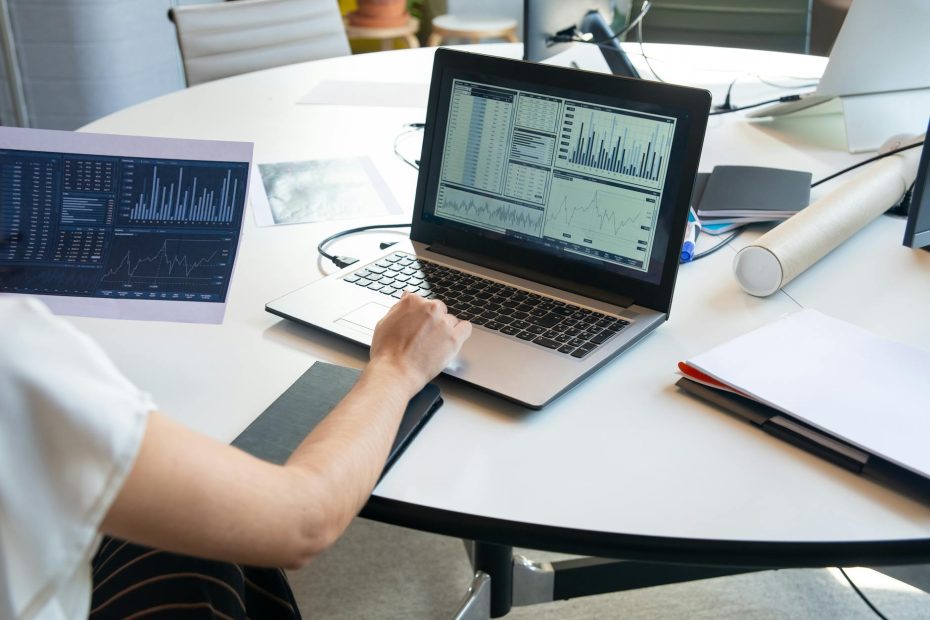 photograph of a paper and laptop with graphs