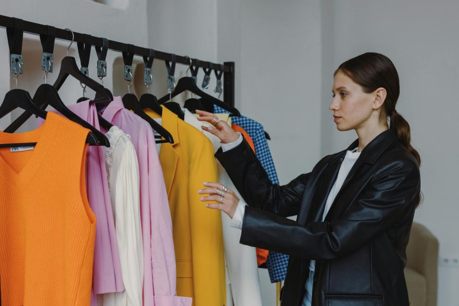 woman in black leather jacket standing near clothing rack