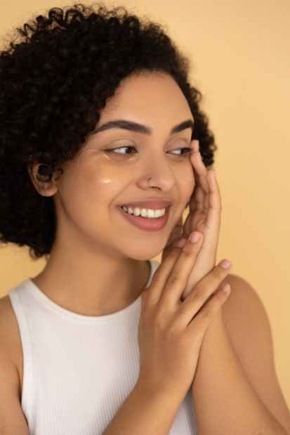 woman in white tank top with under eye mask